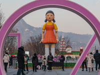 People take photos in front of Young-hee, a robotic doll from Netflix's ''Squid Game,'' at Gwanghwamun Square in Seoul, South Korea, on Dece...