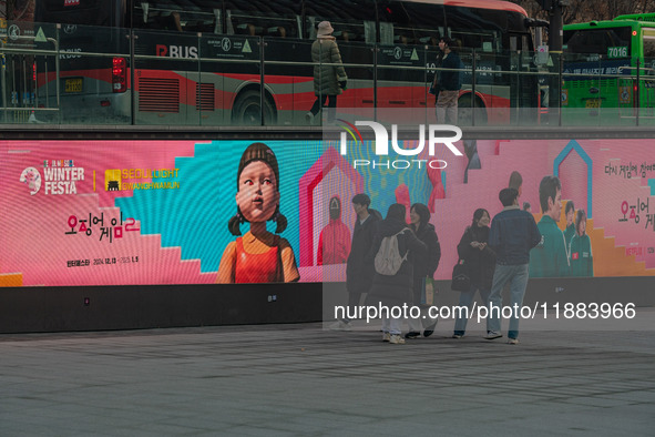 People walk past a displayed billboard for Netflix's ''Squid Game'' new season in Seoul, South Korea, on December 20, 2024. ''Squid Game'' s...