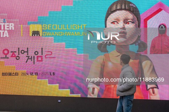 A person walks past a displayed billboard for Netflix's ''Squid Game'' new season in Seoul, South Korea, on December 20, 2024. ''Squid Game'...