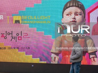 A person walks past a displayed billboard for Netflix's ''Squid Game'' new season in Seoul, South Korea, on December 20, 2024. ''Squid Game'...