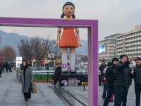 People take photos in front of Young-hee, a robotic doll from Netflix's ''Squid Game,'' at Gwanghwamun Square in Seoul, South Korea, on Dece...