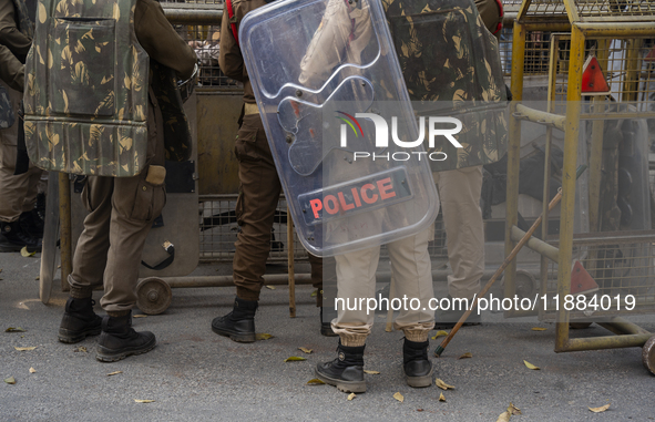 Assam police personnel stand guard during an Indian Youth Congress protest against the state government over the death of a party worker in...