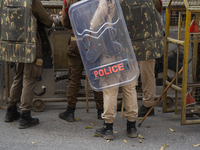 Assam police personnel stand guard during an Indian Youth Congress protest against the state government over the death of a party worker in...