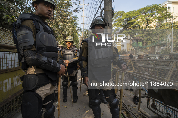 Assam police personnel stand guard during an Indian Youth Congress protest against the state government over the death of a party worker in...