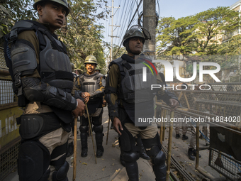 Assam police personnel stand guard during an Indian Youth Congress protest against the state government over the death of a party worker in...