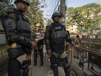 Assam police personnel stand guard during an Indian Youth Congress protest against the state government over the death of a party worker in...