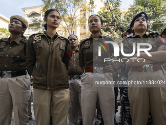 Assam police personnel stand guard during an Indian Youth Congress protest against the state government over the death of a party worker in...