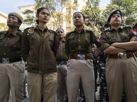 Assam police personnel stand guard during an Indian Youth Congress protest against the state government over the death of a party worker in...