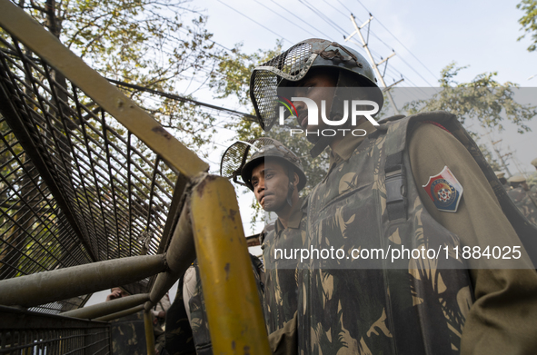 Assam police personnel stand guard during an Indian Youth Congress protest against the state government over the death of a party worker in...