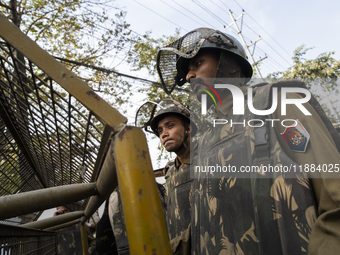 Assam police personnel stand guard during an Indian Youth Congress protest against the state government over the death of a party worker in...