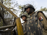 Assam police personnel stand guard during an Indian Youth Congress protest against the state government over the death of a party worker in...