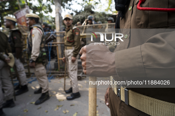 Assam police personnel stand guard during an Indian Youth Congress protest against the state government over the death of a party worker in...