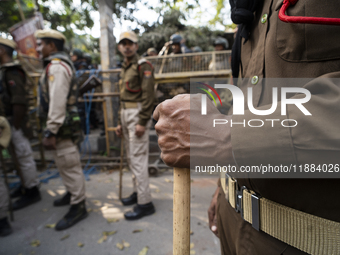 Assam police personnel stand guard during an Indian Youth Congress protest against the state government over the death of a party worker in...