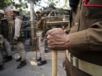 Assam police personnel stand guard during an Indian Youth Congress protest against the state government over the death of a party worker in...