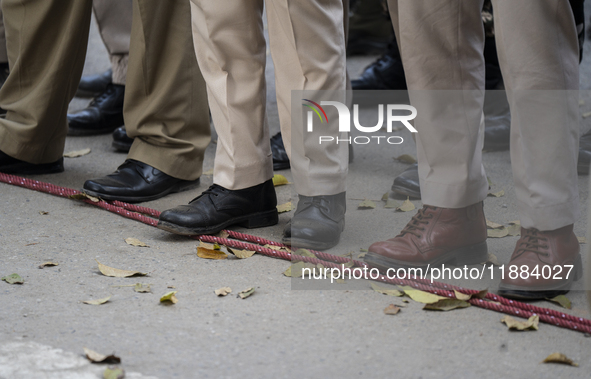 Assam police personnel stand guard during an Indian Youth Congress protest against the state government over the death of a party worker in...