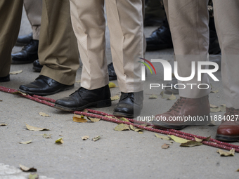 Assam police personnel stand guard during an Indian Youth Congress protest against the state government over the death of a party worker in...