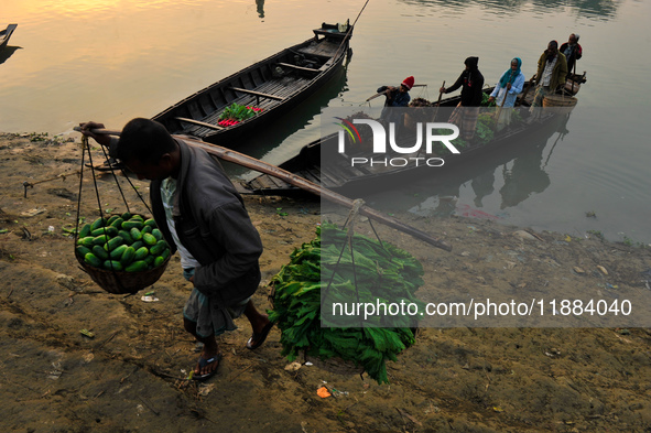 Local vegetable cultivators bring their vegetables to the local wholesale vegetable market after transporting them on a boat in the Tooker B...