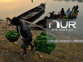 Local vegetable cultivators bring their vegetables to the local wholesale vegetable market after transporting them on a boat in the Tooker B...