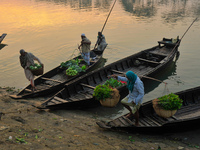 Local vegetable cultivators bring their vegetables to the local wholesale vegetable market after transporting them on a boat in the Tooker B...