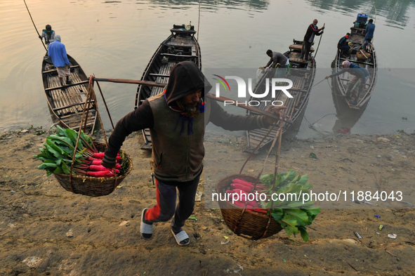 Local vegetable cultivators bring their vegetables to the local wholesale vegetable market after transporting them on a boat in the Tooker B...