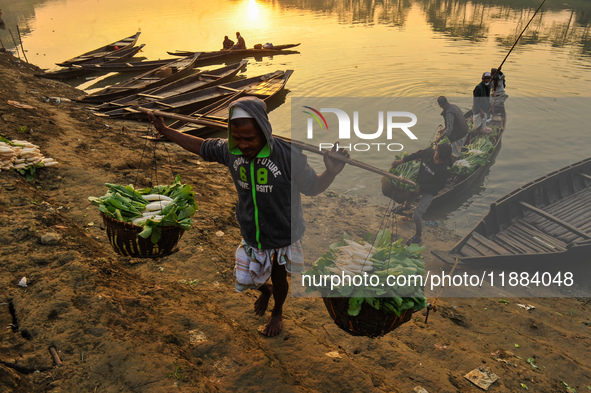 Local vegetable cultivators bring their vegetables to the local wholesale vegetable market after transporting them on a boat in the Tooker B...