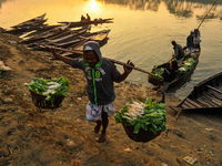 Local vegetable cultivators bring their vegetables to the local wholesale vegetable market after transporting them on a boat in the Tooker B...