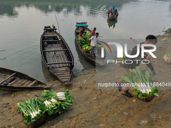 Local vegetable cultivators bring their vegetables to the local wholesale vegetable market after transporting them on a boat in the Tooker B...