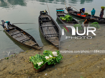 Local vegetable cultivators bring their vegetables to the local wholesale vegetable market after transporting them on a boat in the Tooker B...