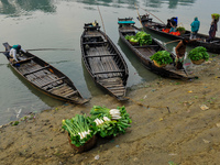 Local vegetable cultivators bring their vegetables to the local wholesale vegetable market after transporting them on a boat in the Tooker B...