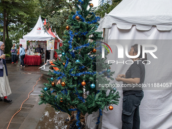 A woman arranges a Christmas tree near the MRT Station in Jakarta, Indonesia, on December 20, 2024. The world's most populous Muslim country...