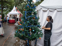 A woman arranges a Christmas tree near the MRT Station in Jakarta, Indonesia, on December 20, 2024. The world's most populous Muslim country...