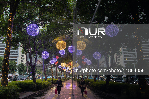 People walk on an illuminated street in Jakarta, Indonesia, on December 20, 2024. The world's most populous Muslim country prepares for Chri...