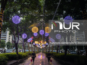 People walk on an illuminated street in Jakarta, Indonesia, on December 20, 2024. The world's most populous Muslim country prepares for Chri...