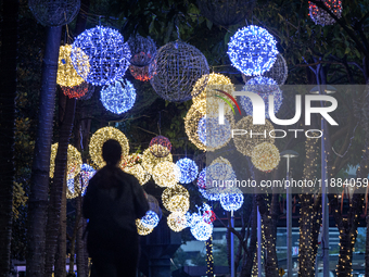 People walk on an illuminated street in Jakarta, Indonesia, on December 20, 2024. The world's most populous Muslim country prepares for Chri...