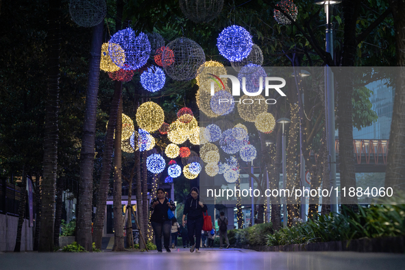 People walk on an illuminated street in Jakarta, Indonesia, on December 20, 2024. The world's most populous Muslim country prepares for Chri...