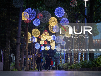 People walk on an illuminated street in Jakarta, Indonesia, on December 20, 2024. The world's most populous Muslim country prepares for Chri...