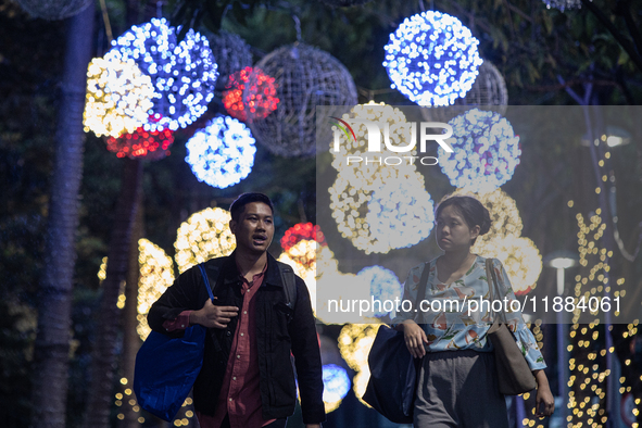 People walk on an illuminated street in Jakarta, Indonesia, on December 20, 2024. The world's most populous Muslim country prepares for Chri...