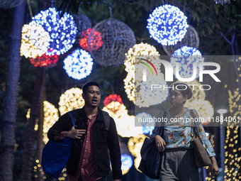 People walk on an illuminated street in Jakarta, Indonesia, on December 20, 2024. The world's most populous Muslim country prepares for Chri...