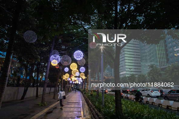 People walk on an illuminated street in Jakarta, Indonesia, on December 20, 2024. The world's most populous Muslim country prepares for Chri...