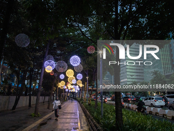 People walk on an illuminated street in Jakarta, Indonesia, on December 20, 2024. The world's most populous Muslim country prepares for Chri...