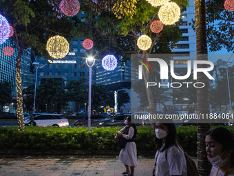 People walk on an illuminated street in Jakarta, Indonesia, on December 20, 2024. The world's most populous Muslim country prepares for Chri...