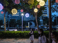 People walk on an illuminated street in Jakarta, Indonesia, on December 20, 2024. The world's most populous Muslim country prepares for Chri...