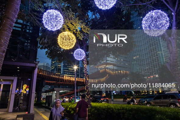 People walk on an illuminated street in Jakarta, Indonesia, on December 20, 2024. The world's most populous Muslim country prepares for Chri...