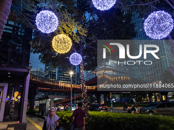 People walk on an illuminated street in Jakarta, Indonesia, on December 20, 2024. The world's most populous Muslim country prepares for Chri...