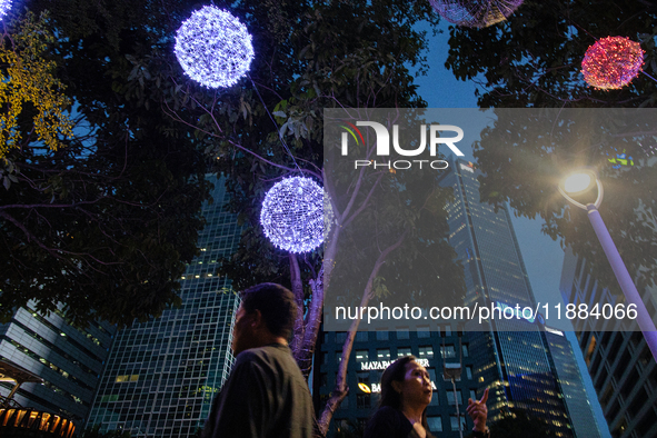 People walk on an illuminated street in Jakarta, Indonesia, on December 20, 2024. The world's most populous Muslim country prepares for Chri...