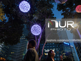 People walk on an illuminated street in Jakarta, Indonesia, on December 20, 2024. The world's most populous Muslim country prepares for Chri...