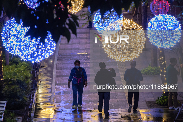 People walk on an illuminated street in Jakarta, Indonesia, on December 20, 2024. The world's most populous Muslim country prepares for Chri...