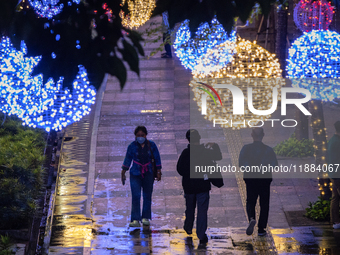 People walk on an illuminated street in Jakarta, Indonesia, on December 20, 2024. The world's most populous Muslim country prepares for Chri...