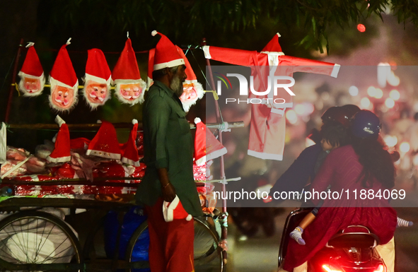 A motorist looks for Santa Claus costumes from a street vendor at a roadside in Hyderabad, India, on December 20, 2024, ahead of the Christm...