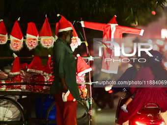 A motorist looks for Santa Claus costumes from a street vendor at a roadside in Hyderabad, India, on December 20, 2024, ahead of the Christm...